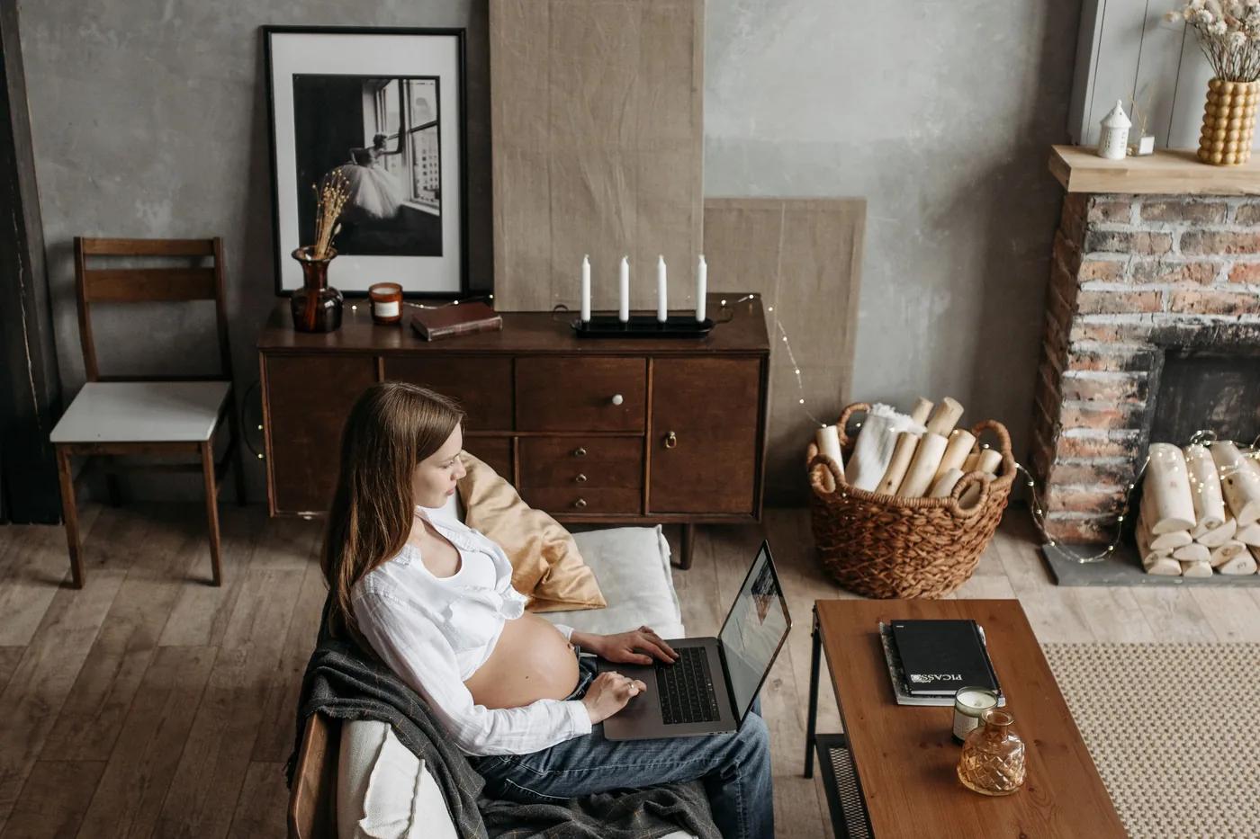 Someone working on a laptop in an armchair in a warm living room